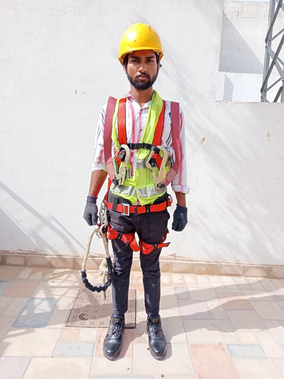 Technician wearing helmet and fall protection harness