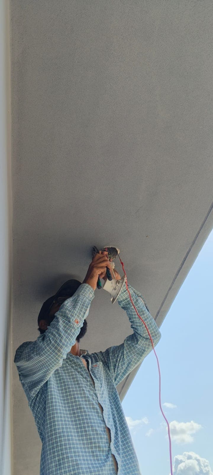 Technician cutting ceiling for CCTV installation